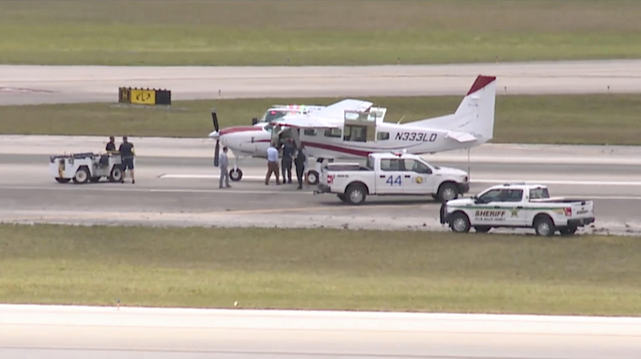 This still image from video by WPTV-TV shows emergency personnel surrounding a Cessna plane at Palm Beach International Airport in West Palm Beach, Florida, on Tuesday. A passenger with no flying experience was able to land the plane safely with help of air traffic controllers after the pilot was too sick to handle the controls.