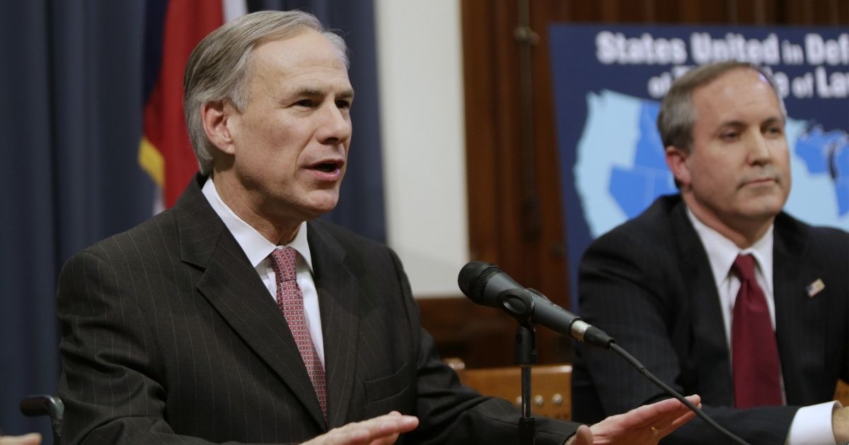 Texas Gov. Greg Abbott speaks alongside state Attorney General Ken Paxton during a news conference in Austin on Feb. 18, 2015.