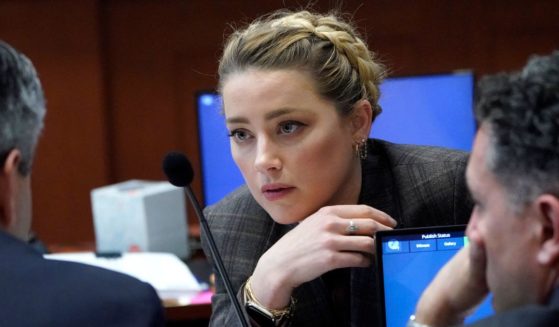Actress Amber Heard talks to her attorney during a break at the Fairfax County Circuit Court in Fairfax, Virginia, on Monday.