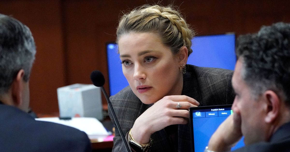 Actress Amber Heard talks to her attorney during a break at the Fairfax County Circuit Court in Fairfax, Virginia, on Monday.