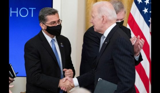 Health and Human Services Secretary Xavier Becerra, left, shakes hands with President Joe Biden after an event in the East Room of the White House on Feb. 2.