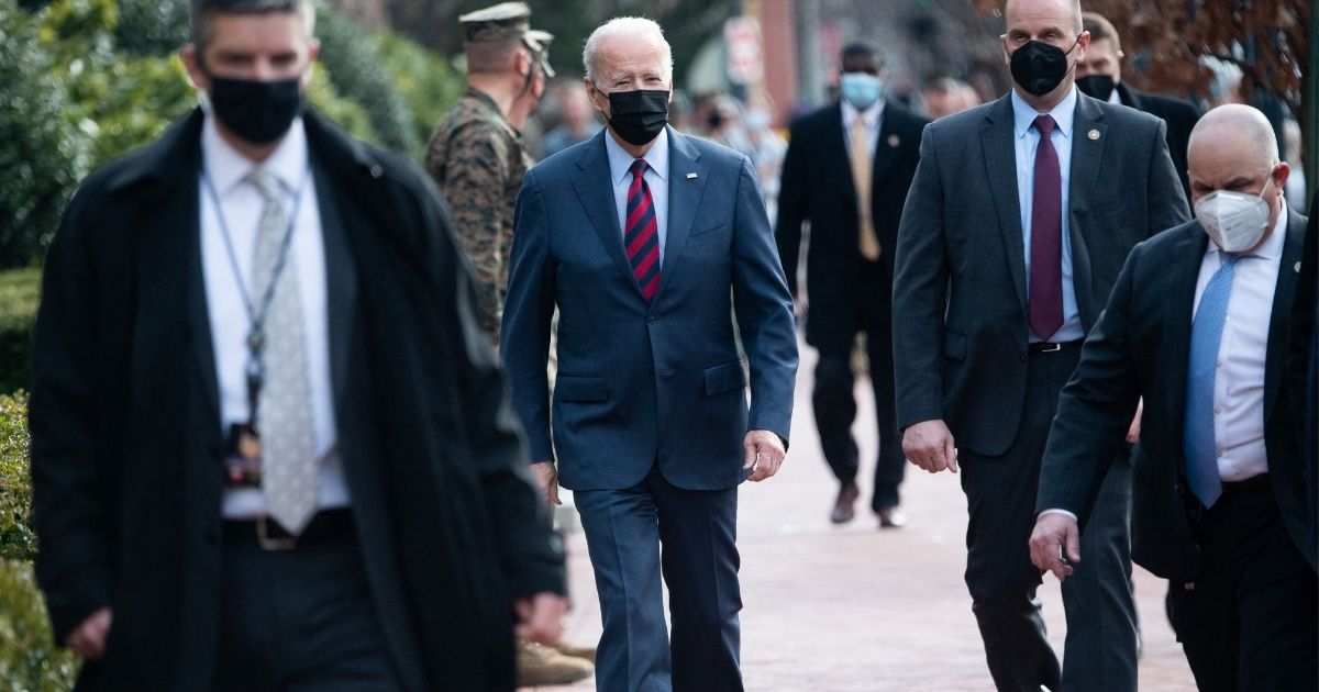 Secret Service members surround President Joe Biden as he walks down Barracks Row in Washington on Jan. 25