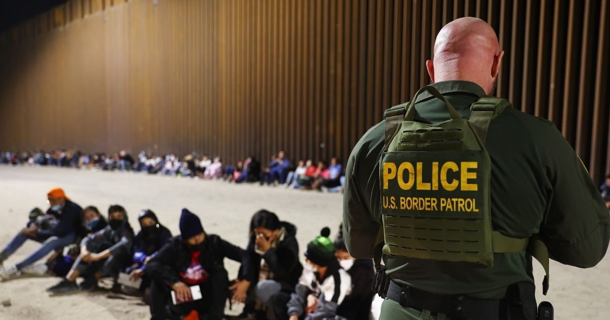 A U.S. Border Patrol agent processes migrants after they illegally crossed the border from Mexico into Yuma, Arizona, on Wednesday.