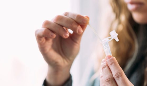 A woman takes an at-home antigen test in this stock photo.