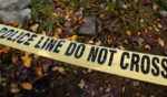 Police crime scene tape lays on the ground outside a crime scene in Detroit, Michigan.