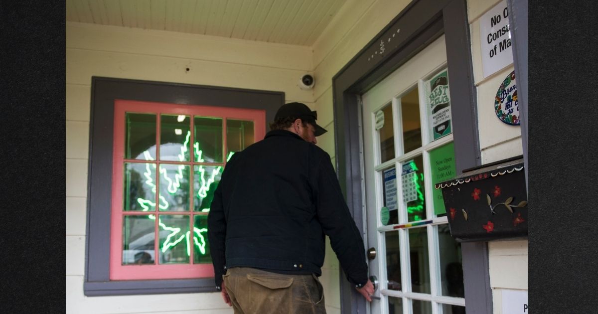 A customer enters a marijuana dispensary in a 2016 file photo. Washington State has banned use of the word 'marijuana' from state laws, saying the term has racist origins