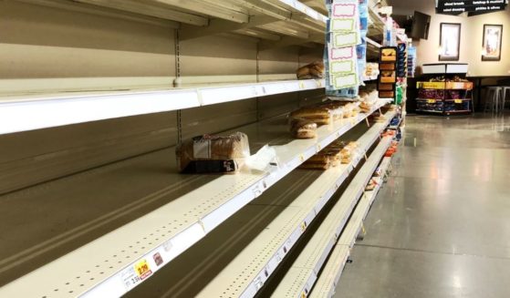 This photo shows a nearly empty bread shelf at a grocery store.