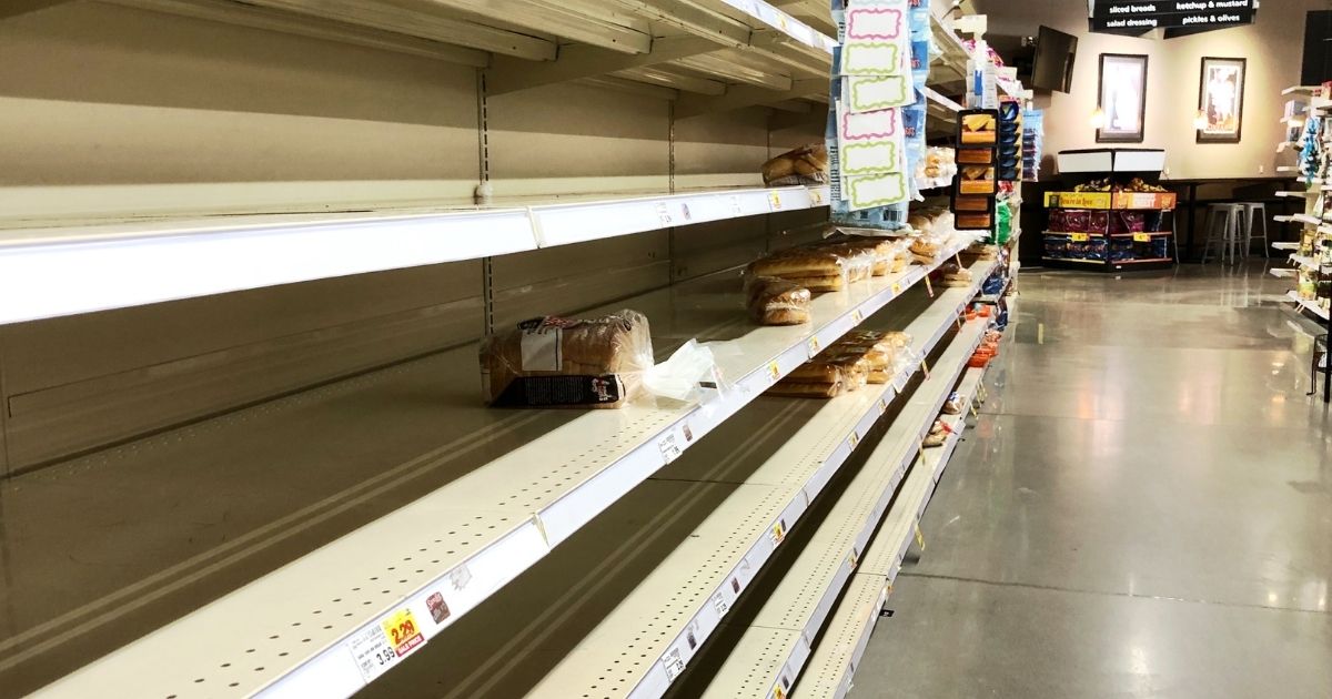 This photo shows a nearly empty bread shelf at a grocery store.