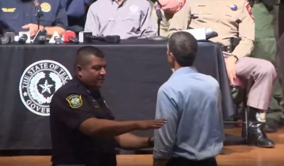 A police officer approaches Beto O'Rourke as he interrupts a news conference in Uvalde, Texas, on Wednesday.