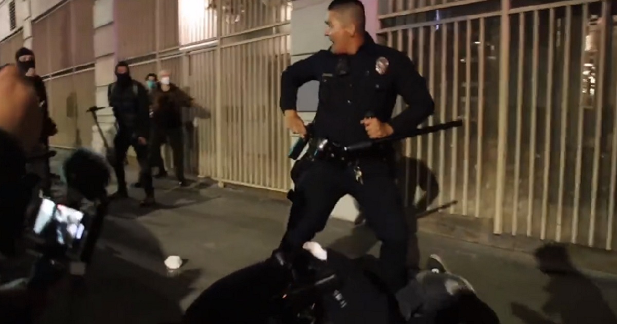 Police in Los Angeles are surrounded by a mob during pro-abortion violence on Tuesday.