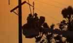 Workers repair power lines near Irvine, California, on Dec. 3, 2020.