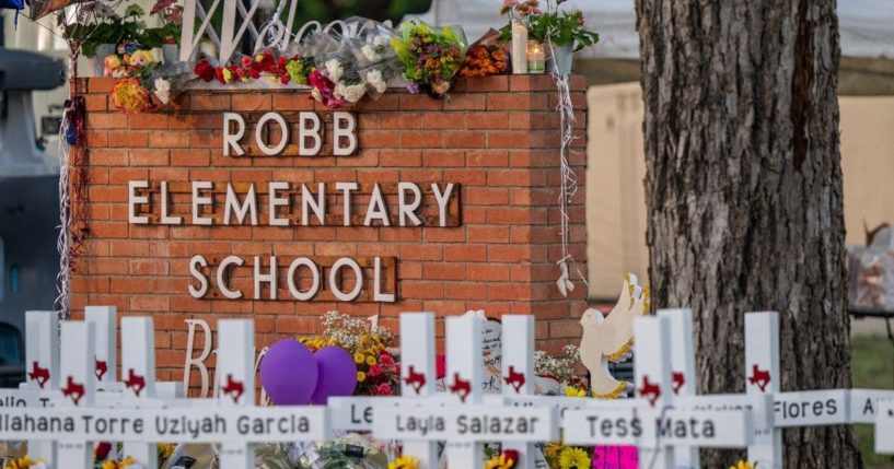 A memorial is seen surrounding the welcome sign at Robb Elementary School in Uvalde, Texas, on Thursday following the mass shooting there on Tuesday.