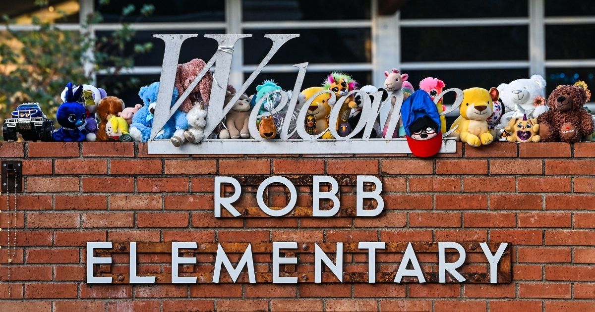 Hundreds of mementos decorate the sign and front lawn of Robb Elementary School in Uvalde, Texas, as a part of a makeshift memorial for the victims of the shooting that took place on Tuesday.
