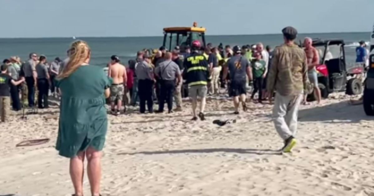 First responders are pictured at the scene of a New Jersey beach where Levi Caverly, 18, and his 17-year-old sister became trapped in a 10-foot hole they had dug at the beach. Unfortunately, by the time they reached the siblings Levi had not survived being buried alive.