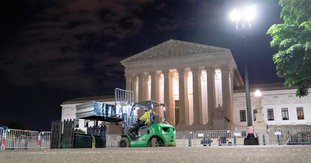On Wednesday night, workers set up un-scable fencing around the U.S. Supreme Court in Washington, D.C., in preparation for protests sparked by a leaked draft of a majority opinion from the justices that would overturn the 1973 Roe v. Wade decision.