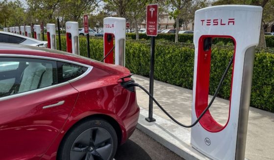 Tesla electric vehicles are lined up at a public battery charging station in Goleta, Calif., in this file photo from March 2022. Close to 130,000 Teslas are being recalled due to a potential problem with the infotainment central processing unit overheating during fast charging.