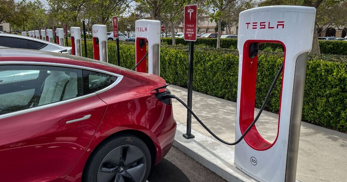 Tesla electric vehicles are lined up at a public battery charging station in Goleta, Calif., in this file photo from March 2022. Close to 130,000 Teslas are being recalled due to a potential problem with the infotainment central processing unit overheating during fast charging.