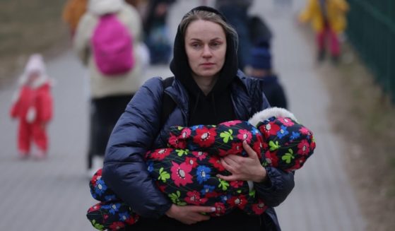 A mother carrying an infant arrives in Poland from war-torn Ukraine on March 4 near Medyka, Poland.