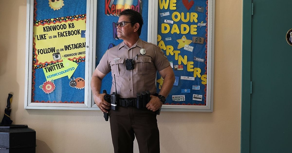 A Miami-Dade Police officer is pictured guarding the entrance to an elementary school in a 2018 file photo.