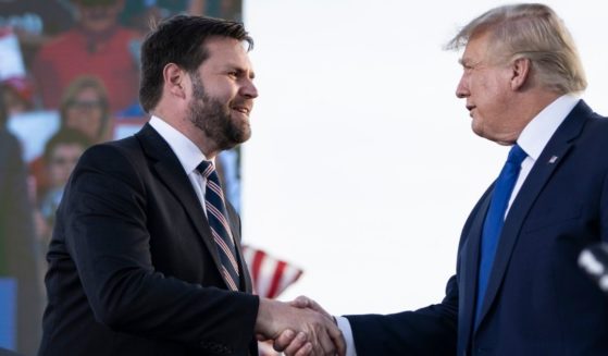 J.D. Vance, a Republican candidate for U.S. Senate in Ohio, shakes hands with former President Donald Trump during a rally at the Delaware County Fairgrounds in Delaware, Ohio, on April 23.