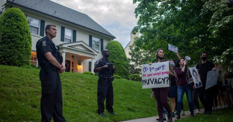 Abortion advocates hold a demonstration as police officers look on outside the home of Supreme Court Chief Justice John Roberts on Wednesday in Chevy Chase, Maryland.