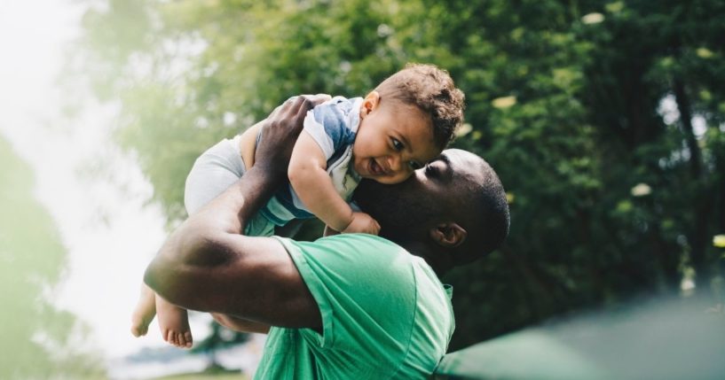 A father holds his son in this stock image.