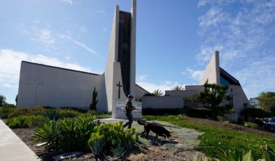 A K-9 unit checks the grounds of Geneva Presbyterian Church in Laguna Woods, California, after a fatal shooting on Sunday.