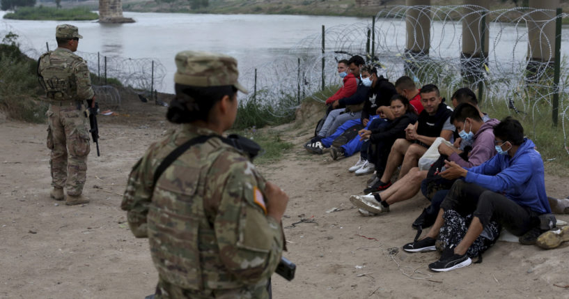 Migrants who had illegally crossed the Rio Grande into the U.S. await the arrival of U.S. Border Patrol agents in Eagle Pass, Texas, on Friday.
