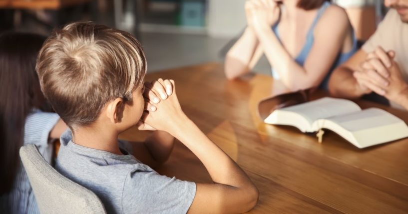 A family prays in this stock image.