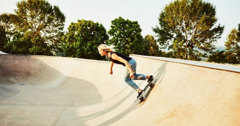 A girl rides a skateboard in this stock image.