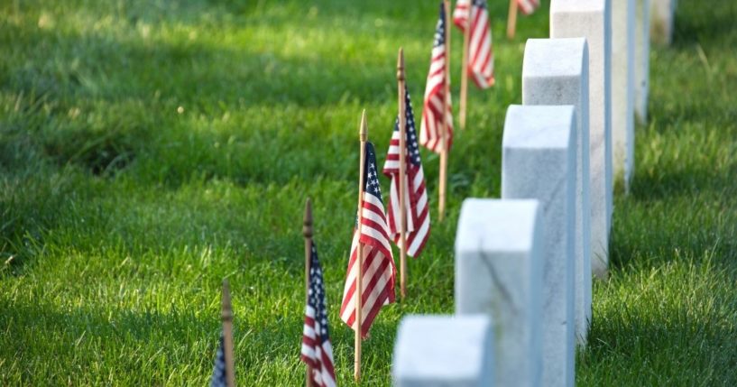 American flags are seen planted at graves in this stock image.