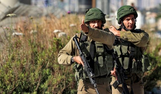 Israeli soldiers confront journalists approaching the Israeli-controlled Hawara checkpoint on Tuesday.