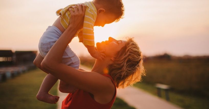 A mother lifts up her child in this stock image.