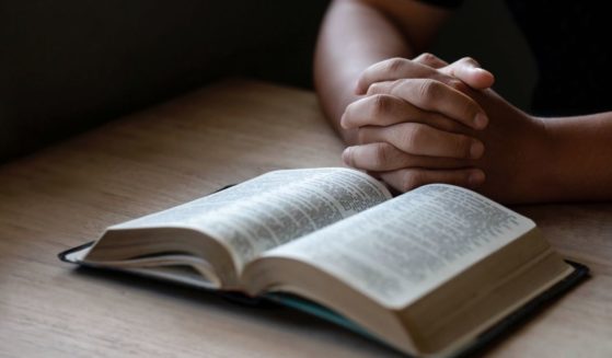 A man prays in the above stock image.