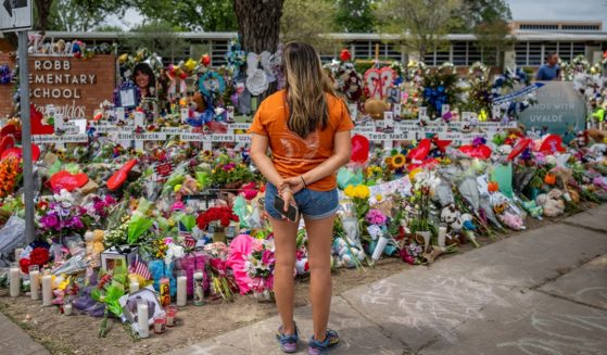 A woman pauses Tuesday at a memorial dedicated to the 19 children and two adults killed in last week's mass shooting at Robb Elementary School in Uvalde, Texas.
