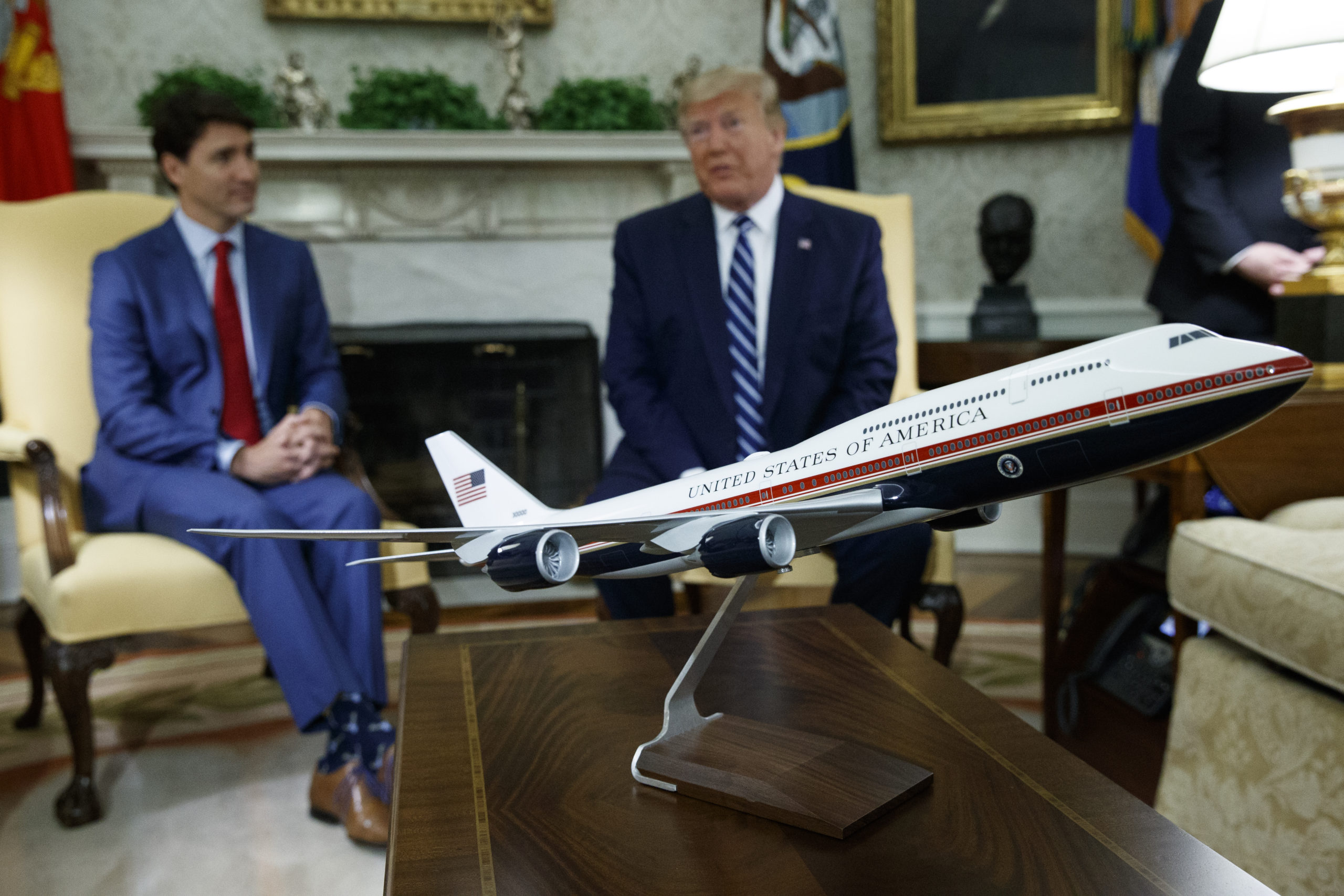 A model of the new Air Force One design sits on a table during a meeting between President Donald Trump and Canadian Prime Minister Justin Trudeau in the Oval Office of the White House, in this file photo from June 20, 2019. President Joe Biden's administration has scrapped former President Trump's red, white and blue design for the new generation of presidential aircraft after an Air Force review suggested it would raise costs and delay the delivery of the new jets.
