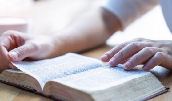 A woman reads the Bible in this stock image.