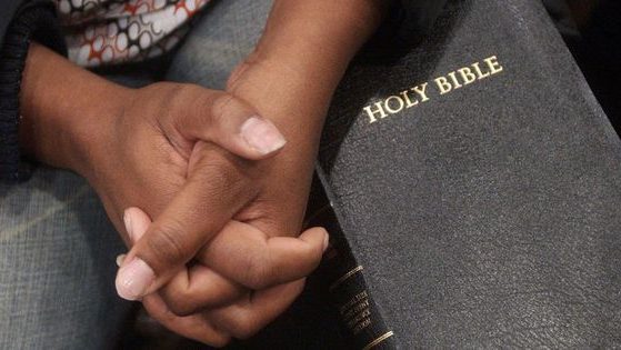 Shontae Scott of Atlanta holds her hands together above a Bible in Lithonia, Georgia, on February 7, 2006.