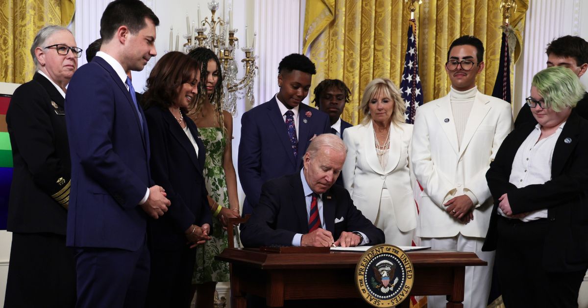 Vice President Kamala Harris, third from left, and others watch as President Joe Biden signs an executive order on LGBT rights in the East Room of the White House in Washington on Wednesday.