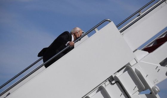 U.S. President Joe Biden trips while boarding Air Force One at Joint Base Andrews, Maryland, on March 19, 2021.