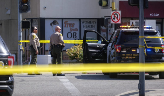 Police officers stand guard Wednesday near a crime scene where two police officers were shot and killed Tuesday at a motel in El Monte, Calif.