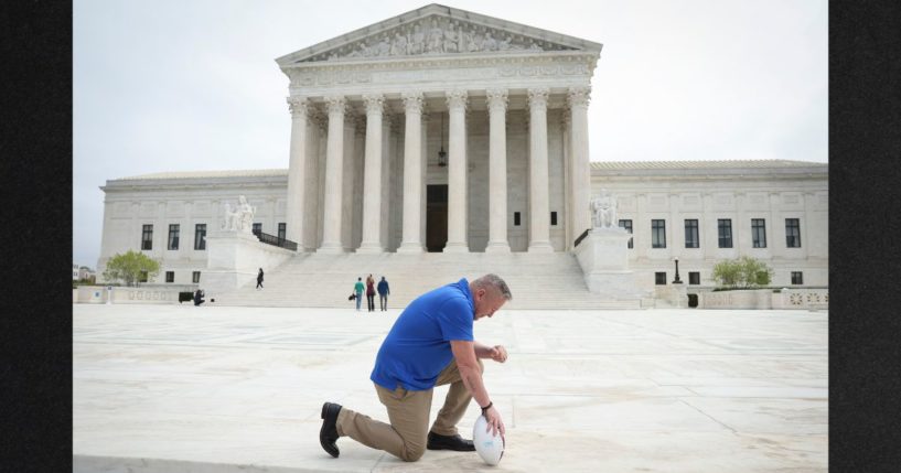Former Bremerton High School assistant football coach Joe Kennedy takes a knee in front of the U.S. Supreme Court after his legal case, Kennedy vs. Bremerton School District, was argued before the court on April 25 in Washington, DC. Kennedy was terminated from his job by Bremerton public school officials in 2015 after refusing to stop his on-field prayers after football games.