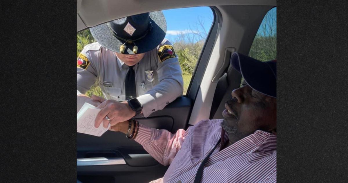 North Carolina State Trooper Jaret Doty prays with Anthony Geddis during a traffic stop. The photo, taken by Geddis' daughter, gained national attention after a news network did a story about the interaction.