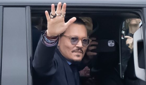 Actor Johnny Depp waves as he arrives at the Fairfax County Circuit Court in Fairfax, Virginia, for his civil trial against ex-wife Amber Heard on Friday.