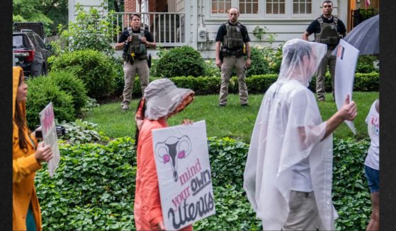 Pro-abortion protesters march past Supreme Court Justice Brett Kavanaugh's home on Wednesday in Chevy Chase, Maryland. An armed man was arrested near Kavanaugh's home that morning.
