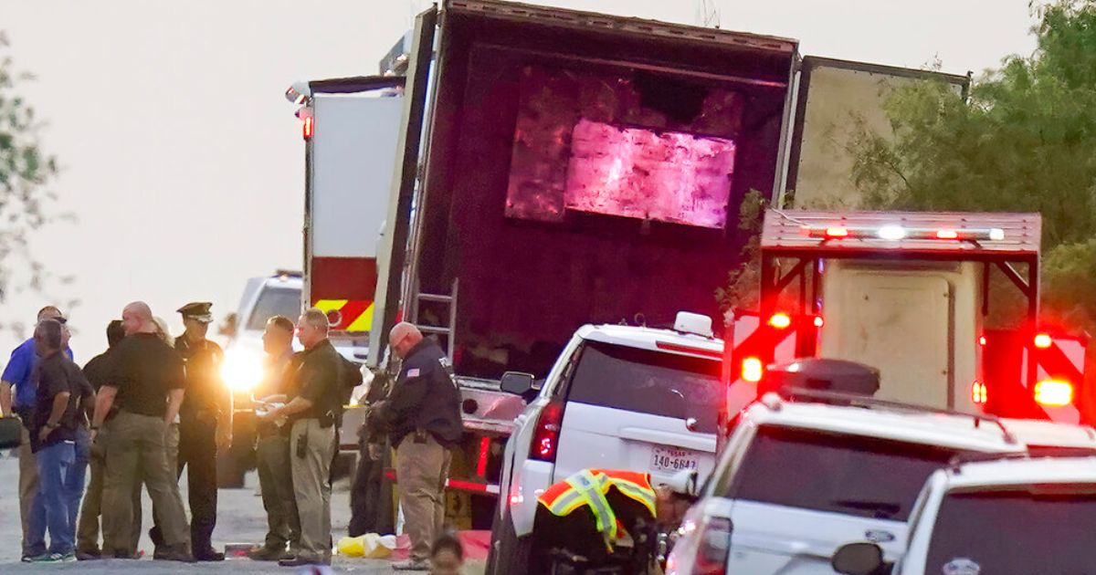 Police and other first responders work the scene where officials say dozens of people were found dead and multiple others were taken to hospitals with heat-related illnesses after a semi trailer containing suspected migrants was found Monday in San Antonio.