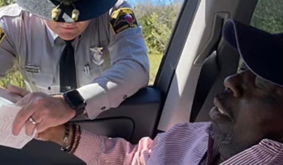 North Carolina State Highway Patrol Trooper Jaret Doty, left, asked if he could pray with Anthony Geddis, right, after pulling his daughter, Ashlye Wilkerson, over for speeding on their way back from Geddis' chemotherapy treatment.