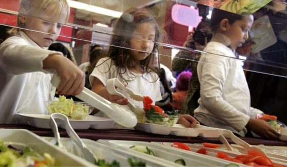 Students at a Chicago elementary school dig into a salad bar in the school's lunchroom in a file photo from March 2006. Attorneys general from 26 states are fighting the Biden administration, which is holding federal school lunch money hostage unless districts bow to the Biden's radical woke agenda.