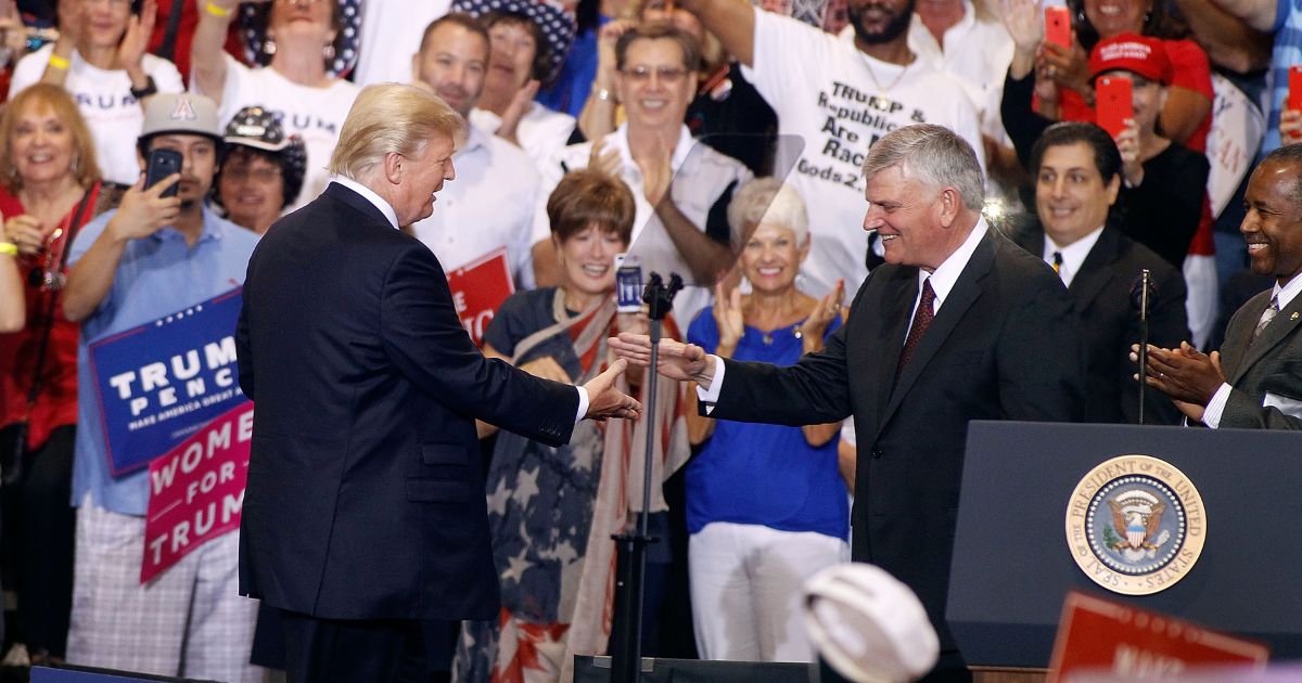 Former U.S. President Donald Trump and Franklin Graham greet at the Trump rally in Phoenix, on Aug. 22.