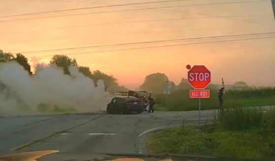 Officers from the police department in the village of Oswego, Illinois, rescue the occupants from a smoldering vehicle at a crash site in the village recently.